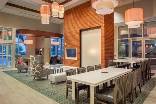 uma sala de jantar com mesas, cadeiras e janelas em Residence Inn by Marriott Orlando Downtown em Orlando