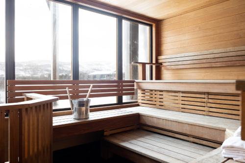 una sauna con paredes de madera y grandes ventanas en Highland Lodge Fjellandsby, en Geilo