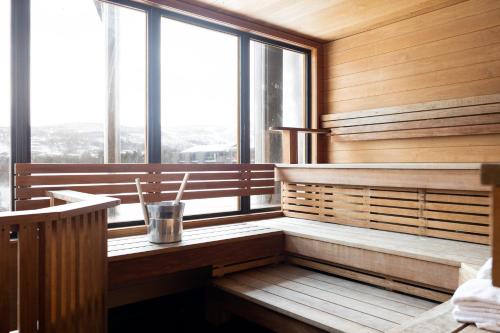 a sauna with wooden walls and large windows at Highland Lodge Fjellandsby in Geilo