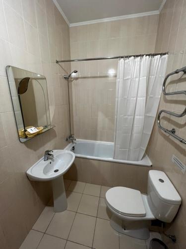 a bathroom with a toilet and a sink and a tub at Zolotoy Fazan in Mykolaiv