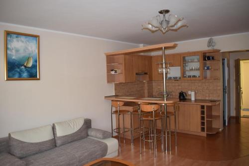 a living room with a couch and a kitchen at Apartament Wictor Międzyzdroje in Międzyzdroje