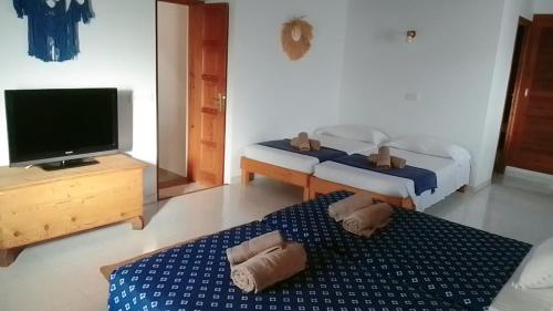 ein Schlafzimmer mit einem Bett, einem TV und 2 Handtüchern in der Unterkunft Casa Pamela in Cala Saona