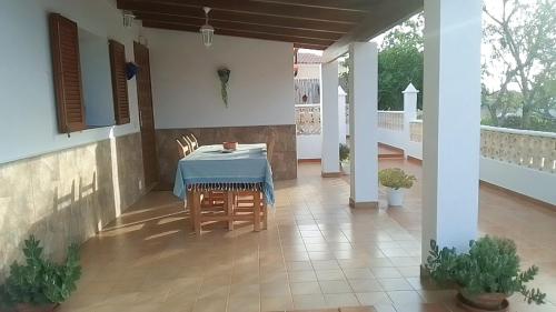 een tafel en stoelen op de veranda van een huis bij Casa Pamela in Cala Saona