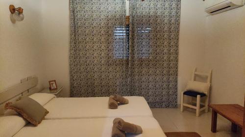 ein Schlafzimmer mit 2 Betten und Hausschuhen darauf in der Unterkunft Casa Pamela in Cala Saona