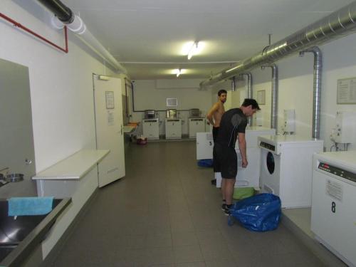 two men standing in a large room with machines at Laax with indoor and outside pool, sauna, 200 Meter to Ski lift , Fitnessroom, Tennis Place, Joyroom, Parkstadion Reserve in Laax