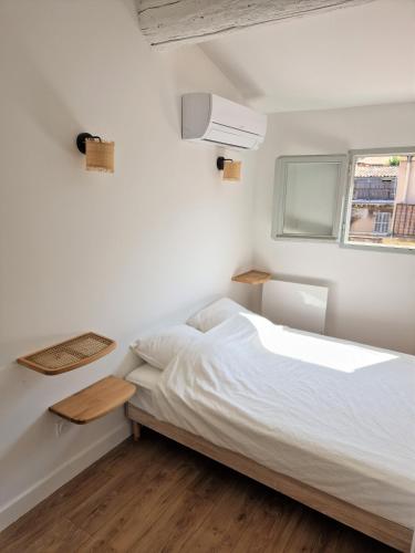 une chambre blanche avec un lit et une fenêtre dans l'établissement Terrasse - Hyper centre - 2 chambres - Parking gratuit - Calme & lumineux - Arrivée autonome, à Marseille