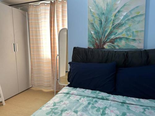 a bedroom with a bed with blue pillows and a mirror at New Avida Cebu 2BR(50mbps,6pax) in Cebu City