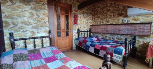 a bedroom with two beds in a room with stone walls at Guest House Irina Tbilisi in Tbilisi City