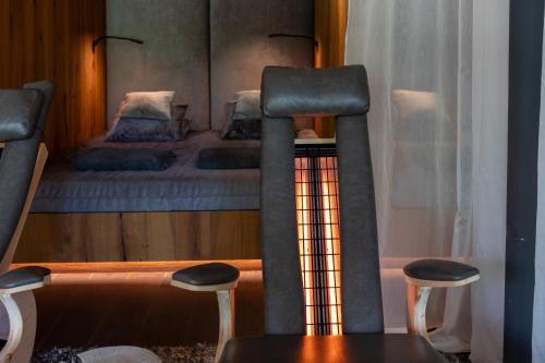 a bedroom with a bunk bed with two stools at Wellness & Naturresort Reischlhof in Wegscheid