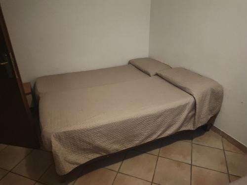 a small bed in a corner of a room at Villa lucia in Acilia
