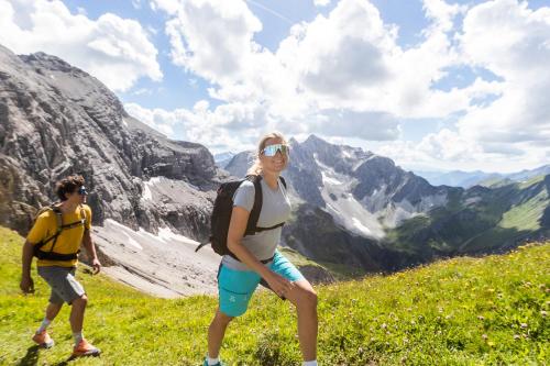 a man and a woman walking on a mountain at Berghaus Schröcken - Hotel Apartments Spa in Schröcken