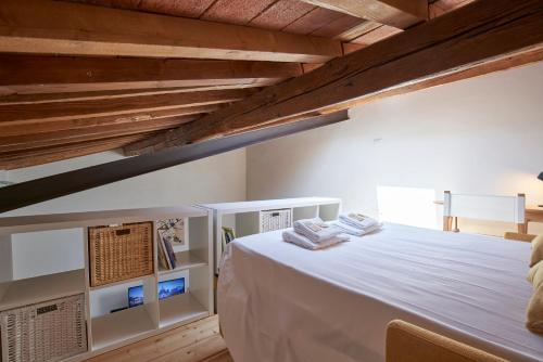 sypialnia z dużym białym łóżkiem i drewnianym sufitem w obiekcie The Chianti Rooster Flat we Florencji