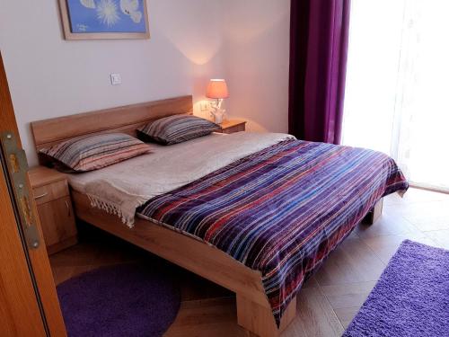 a bedroom with a bed with a colorful comforter at Apartments Maljevic in Bar