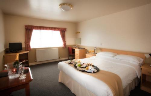 a hotel room with two beds with a tray of food on the bed at Moreton Park Hotel in Chirk