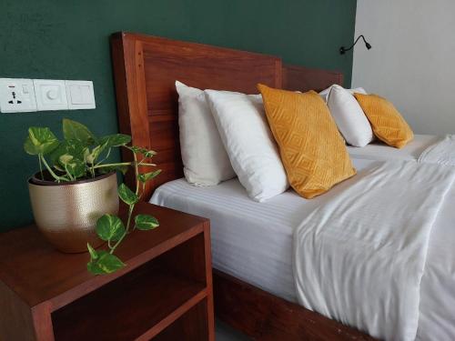 a bedroom with a bed with pillows and a potted plant at Weligama Ocean Breeze in Weligama