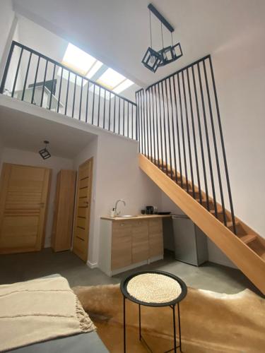 a bedroom with a staircase and a table and a stool at Noclegi u Wojtka in Sromowce Wyżne