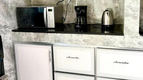 a kitchen with a counter with a microwave and a coffee maker at Wadi Shab Beach Villa in Sur