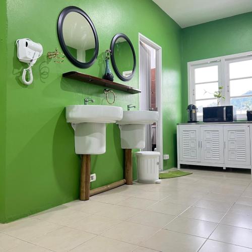 a bathroom with a sink and mirrors on a green wall at Sabai Sabai Poshtel & Motorbike Rental in Koh Tao
