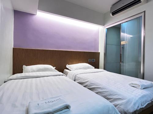 dos camas sentadas una al lado de la otra en una habitación en i hotel-B&B en Hong Kong