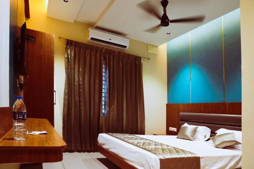 ELITE RESIDENCY في بالني: غرفة نوم بسرير وطاولة ومروحة سقف
