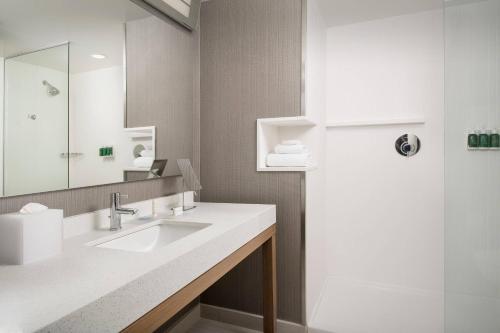 a bathroom with a sink and a mirror at Courtyard by Marriott Las Cruces at NMSU in Las Cruces
