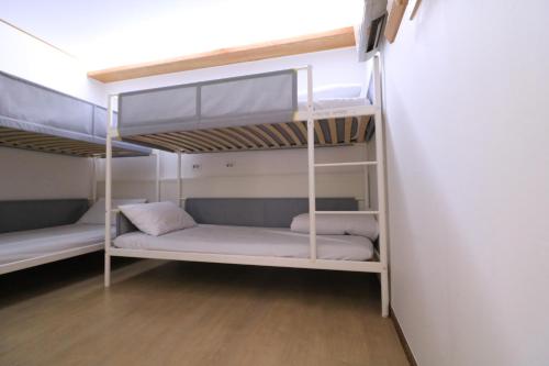 two bunk beds in a room with wooden floors at All Stay Inn Seoul in Seoul