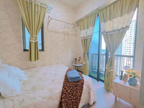 um quarto com uma cama e uma varanda com janelas em 香港欧式装修豪华三室一厅 em Hong Kong