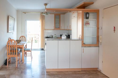 a kitchen with white cabinets and a dining table at Casa Del Sol in Perea