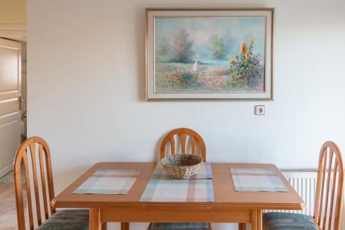 a dining room table with two chairs and a painting on the wall at Casa Del Sol in Perea