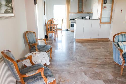 a living room with chairs and a table and a kitchen at Casa Del Sol in Perea