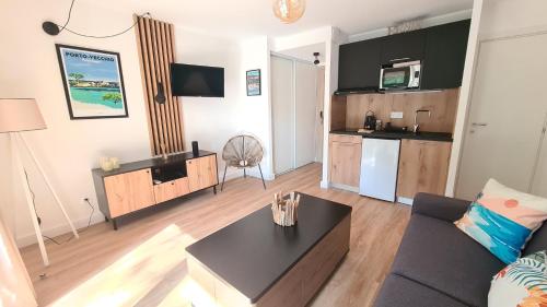 a living room with a couch and a table at Les Studios de Fiori - Studios et Appartement T2 - Cala Rossa - proche Porto Vecchio in Lecci