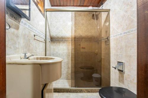 uma casa de banho com um lavatório e um chuveiro com um WC. em Espaço Ideal de Itaipuaçú em Maricá