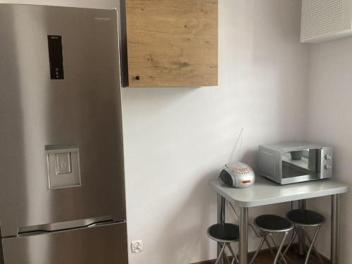 a kitchen with a counter with stools and a microwave at Apartament w Centrum Malborka in Malbork