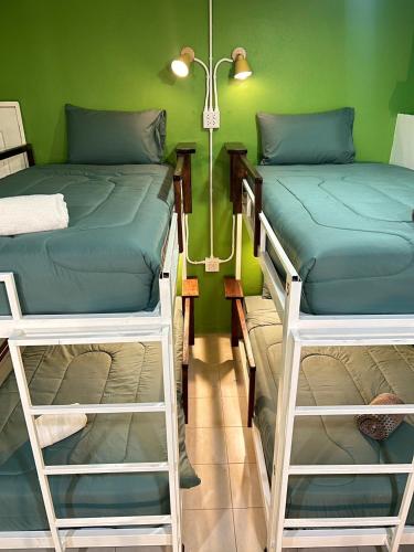 2 literas en una habitación con una pared verde en Sabai Sabai Poshtel & Motorbike Rental, en Ko Tao