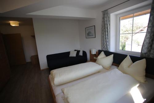 a living room with a white couch and a window at Gästehaus Watschinger in Bad Wimsbach-Neydharting