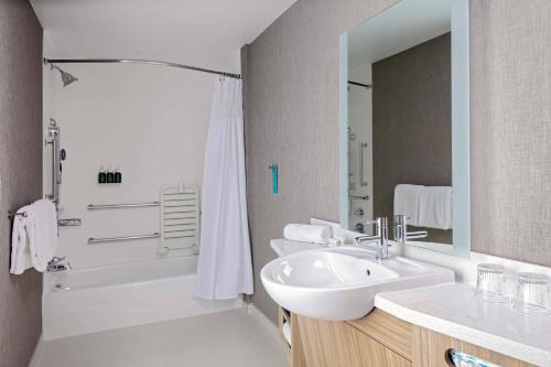 a bathroom with a sink and a tub and a shower at SpringHill Suites by Marriott Kansas City Plaza in Kansas City