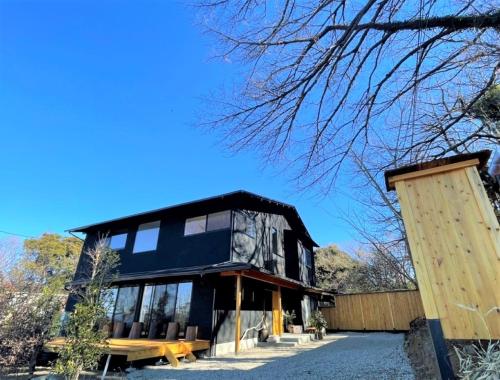 dom z czarnym dachem i drewnianymi drzwiami w obiekcie Open House Sakurasakura - Kamakurayama - - Vacation STAY 14043 w mieście Kamakura