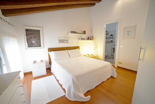 1 dormitorio con cama blanca y suelo de madera en Apartment Deluxe Isola Di Mezzo, en Treviso