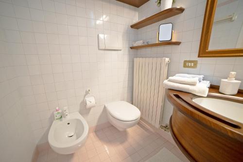 Baño blanco con aseo y lavamanos en Apartment Deluxe Isola Di Mezzo, en Treviso