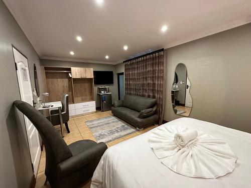 a bedroom with a bed and a chair and a desk at Urban Villas Guest House in Pretoria