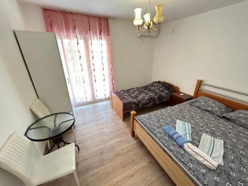 een slaapkamer met 2 bedden en een stoel. bij Bars Ap in Šušanj