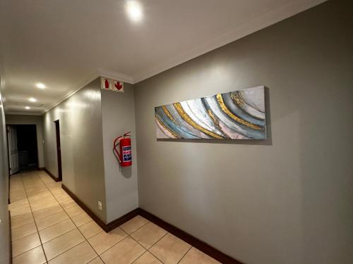 a hallway with a painting on the wall and a fire hydrant at Urban Villas Guest House in Pretoria