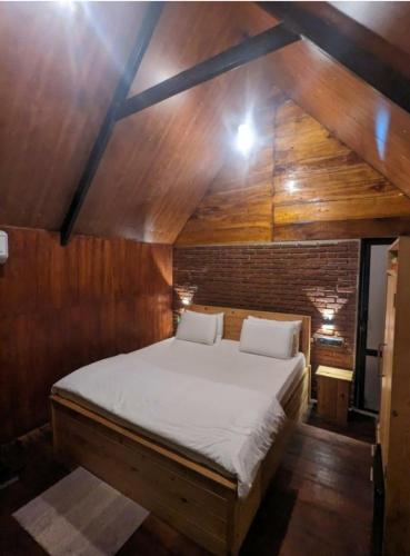 a large bed in a room with a wooden ceiling at Fair View Cottage in Ella