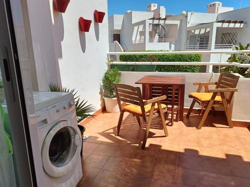 een balkon met een tafel en stoelen en een wasmachine bij Apartamento Palomares in Cuevas del Almanzora