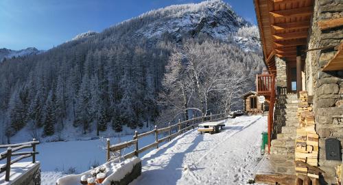 a snow covered mountain in front of a house at Nuit a Pleiney in Saint-Rhémy-en-bosses
