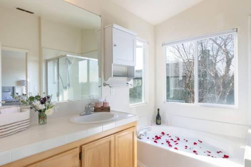 uma casa de banho com uma banheira, um lavatório e um espelho. em Perfect Home In The Wine Country Family Gathering em Santa Rosa