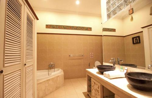 a bathroom with two sinks and a tub at Villa Kaja by Nagisa Bali in Seminyak