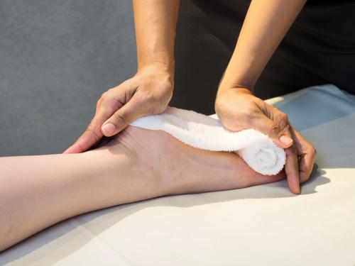 a woman getting a knee massage from a therapist at Dhawa Yura Kyoto in Kyoto