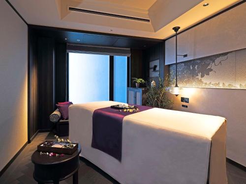 a room with a bed with a table and a chair at Dhawa Yura Kyoto in Kyoto