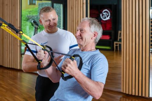 two men are playing with a bow and arrow at Wellness & Naturresort Reischlhof in Wegscheid